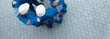 Men with white helmets making circle. Bird-view.